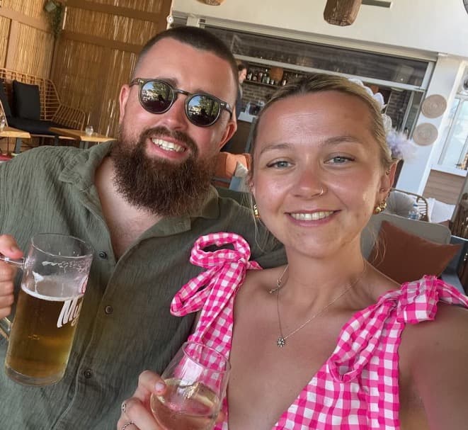 Jordan and Caitlin with a glass of wine and a beer in the sunshine